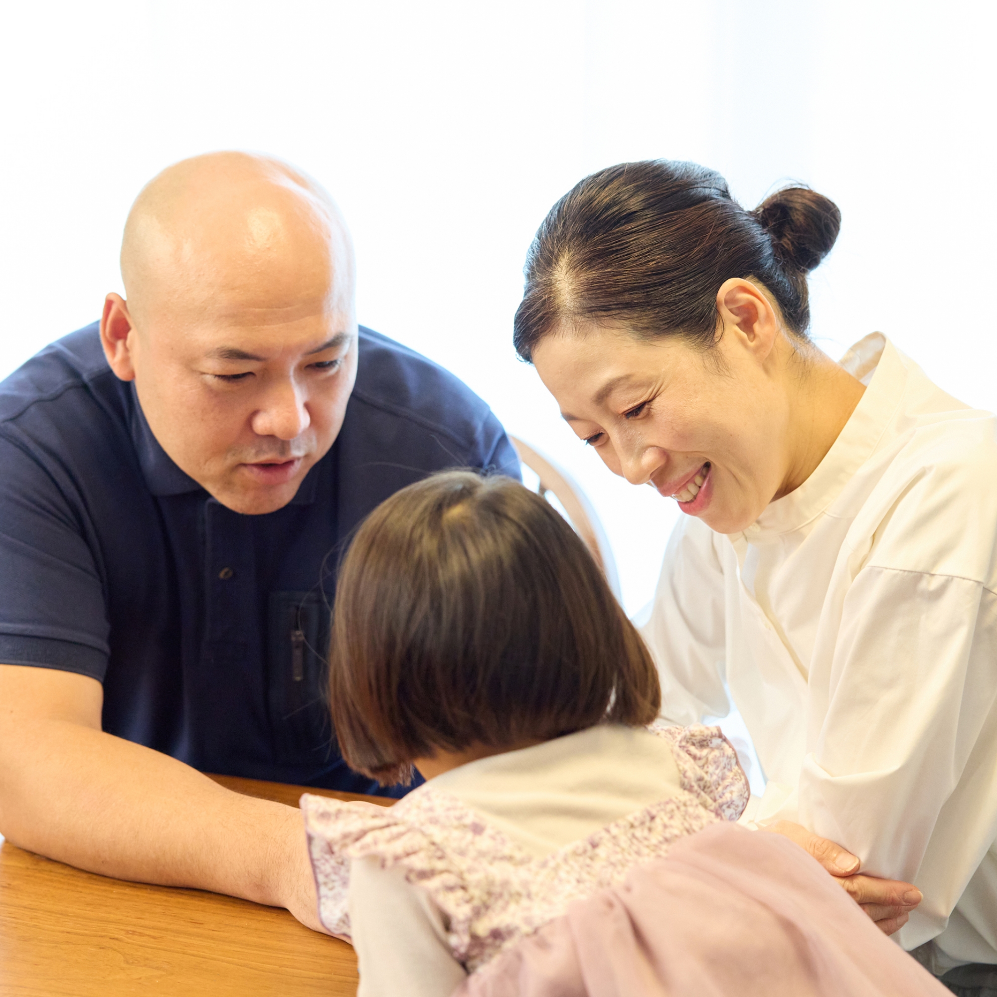 めいちゃん（仮名）と会話を弾ませる三武洋子さん（右）と夫の鉄也さん（左）